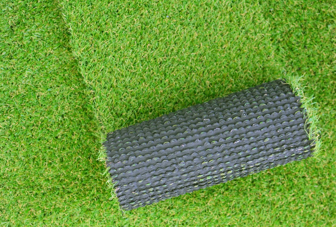 Artificial grass lawn laying background